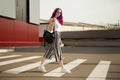 Young woman in stylish clothes with a cup of coffee. Crosses the road. Crosswalk. Zebra. sunglasses, striped pants and white