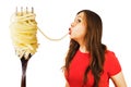 Young woman sucks huge spaghetti from a huge fork isolated on white background
