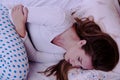 Young woman suffering from abdominal pain while sitting on bed a Royalty Free Stock Photo