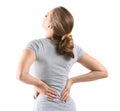 Young woman suffering from back pain on white background