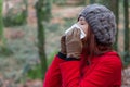Young woman suffering from a cold, flu or allergies blowing her nose Royalty Free Stock Photo