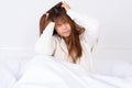 Young woman suffering from headaches after wake up on the bed. Healthcare medical or daily life concept Royalty Free Stock Photo