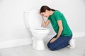 Young woman suffering from nausea at toilet bowl. Space for text Royalty Free Stock Photo