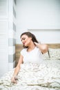 Young Woman Suffering From Neck Pain Sitting On Bed at home Royalty Free Stock Photo