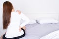 Young woman suffering neck and shoulder pain from uncomfortable bed. Healthcare medical or daily life concept Royalty Free Stock Photo