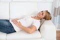 Woman Suffering From Stomach Pain While Lying On Sofa Royalty Free Stock Photo