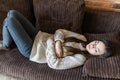 High angle view of young woman suffering from stomachache on sofa at home Royalty Free Stock Photo