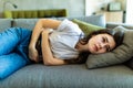 Young woman suffering from stomachache on sofa at home Royalty Free Stock Photo