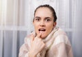 Young woman suffering from toothache, looking to the camera in despair. Close up of a female patient with aching teeth Royalty Free Stock Photo