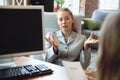 Young woman in suit sitting in office during the job interview with female employee, boss or HR-manager, talking