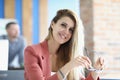 Young woman in suit sitting at table and holding glasses for vision in her hands Royalty Free Stock Photo