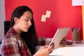 A young woman in suit using a tablet in a colorful office