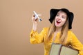 Young woman with a suitcase and toy airplane travel theme Royalty Free Stock Photo
