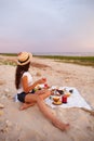 Woman in summer Picnic on the beach at sunset in the white plaid Royalty Free Stock Photo