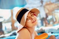 Young woman with sun cream on face holding sunscreen bottle on the beach. Royalty Free Stock Photo