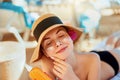 Young woman with sun cream on face holding sunscren bottle on the beach. Female in hat applying moisturizing lotion Royalty Free Stock Photo