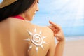 Young woman with sun protection cream on her back at beach Royalty Free Stock Photo