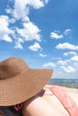 Young woman sunbathing on a beach with a brown hat. Sea and a bl Royalty Free Stock Photo