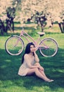 Young woman in sundress enjoying bike trip in park Royalty Free Stock Photo