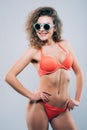 Young woman in sunglasses with beautiful slim perfect body in bikini isolated gray background Royalty Free Stock Photo