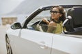 Young woman with sunglasses driving her convertible top automobi Royalty Free Stock Photo