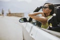 Young woman with sunglasses driving her convertible top automobile on bright sunny day Royalty Free Stock Photo