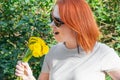Young woman in sunglasses fooling around portrays singing with microphone holding a bouquet of yellow dandelions Royalty Free Stock Photo