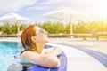 Woman looks out of the pool, hanging on the railing. Royalty Free Stock Photo