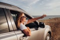 Young Woman in Sunglasses Looks Out of the Car Window on the Sea Background, Girl Enjoying Road Trip at Sunset Royalty Free Stock Photo