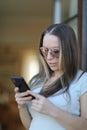 Young woman in sunglasses and phone in hands