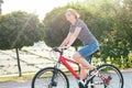 A young woman in sunglasses rides around the city on a bicycle i Royalty Free Stock Photo