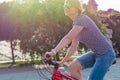 Young woman in sunglasses rides around the city on a bicycle in Royalty Free Stock Photo