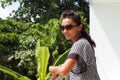 Young woman in sunglasses standing on a balcony