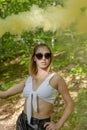 Young woman in sunglasses and summer clothes using smoke bomb Royalty Free Stock Photo