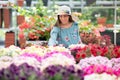 Young woman in sunhat buying plants at a nursery Royalty Free Stock Photo