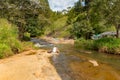 Young woman in a Sunny day in the Tropical waterfall falls from the mountain cliff to the jungle, serene landscape of Diyaluma fal Royalty Free Stock Photo