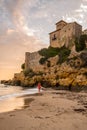 Young Woman in the sunset on Castle of Tamarit seen from the beach on the sunset, Tarragona province, Catalonia, Spain.