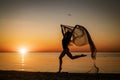 Young woman at sunset jumping on the seashore with background of the sky Royalty Free Stock Photo