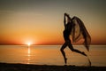 Young woman at sunset jumping on the seashore with background of the sky Royalty Free Stock Photo