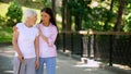 Young woman supporting sick aged lady walking stick, illness depression, rehab Royalty Free Stock Photo