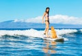 Young Woman Surfing with Her Dog