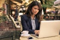 Young woman surfing internet on laptop at cafe. Royalty Free Stock Photo