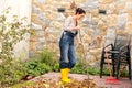 Young woman sweeping autumn leaves veranda Royalty Free Stock Photo