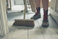 Young woman sweeping the floor