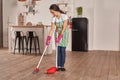 Young woman sweeping floor on the kitchen Royalty Free Stock Photo