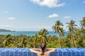 Young woman in swimming pool on vacations relaxing, enjoy and contemplate on sea horizon and tropical nature and palms Royalty Free Stock Photo