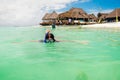 Young woman swims with snorkeling mask in the turquoise ocean