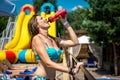 Young woman in a swimsuit drinks water from a bottle. Charming tanned athletic woman stands in the sun in a swimsuit and drinks Royalty Free Stock Photo