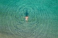 Young woman in a swimsuit running and jumping on sea waves on the beach. View from above. Top, drone view. Royalty Free Stock Photo