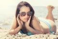 Young woman in swimsuit on the sand with sunglasses Royalty Free Stock Photo